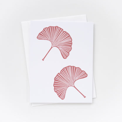white card with pink ginkgo leaf design and matching envelope