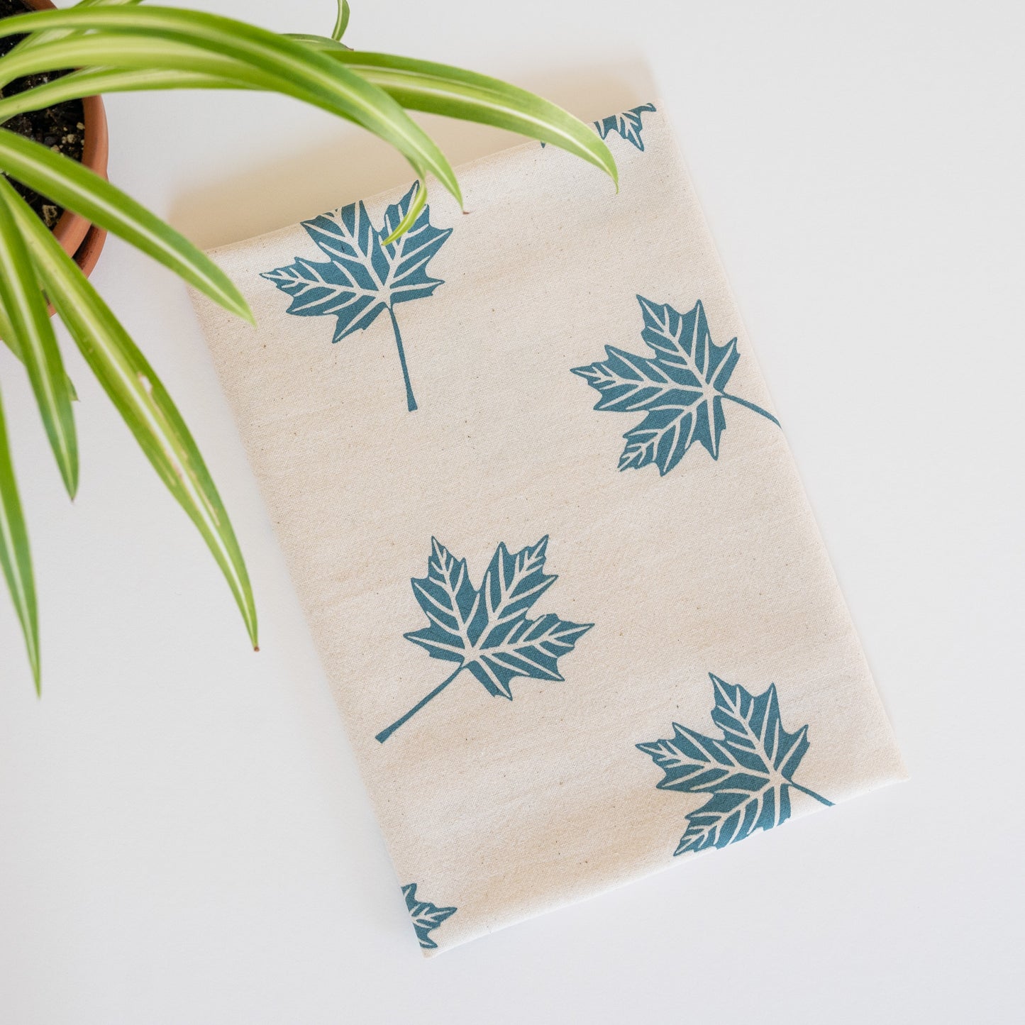 Blue maple leaf cotton tea towel with potted plant