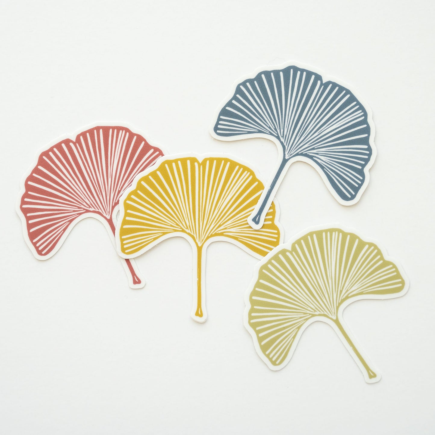 Four vinyl gingko leaf stickers in gold, blue, pink, and green