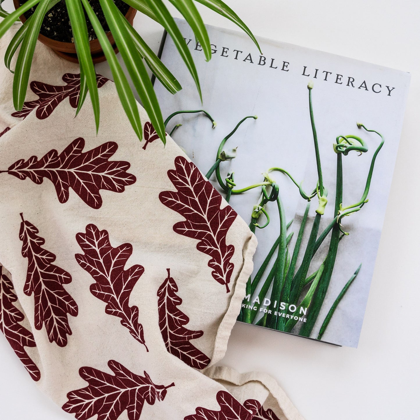 Oak leaf tea towel with cook book and potted plant