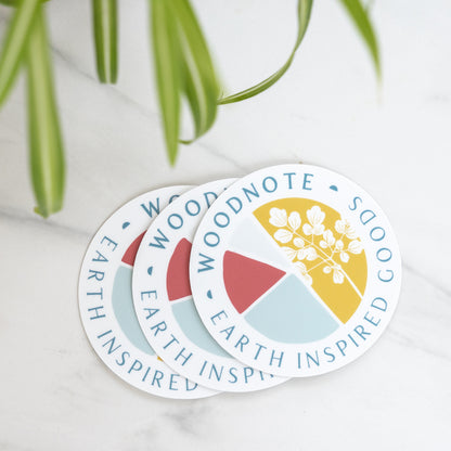 Round vinyl Woodnote logo stickers on marble